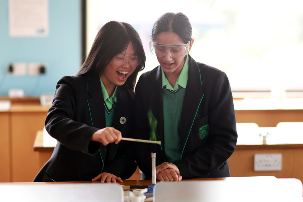 two students playing with a bunsen burner