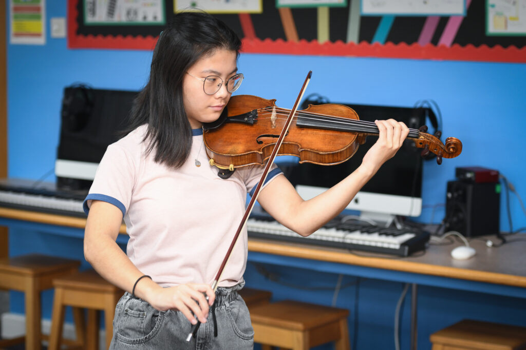 a picture of a student playing a violin