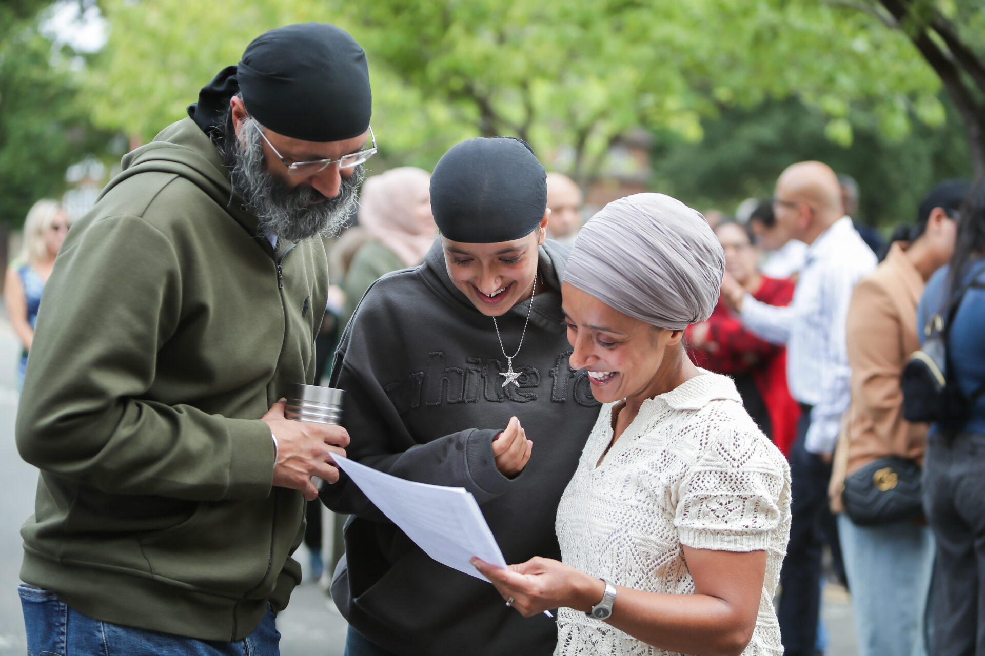 A family of three looking at a document and smiling