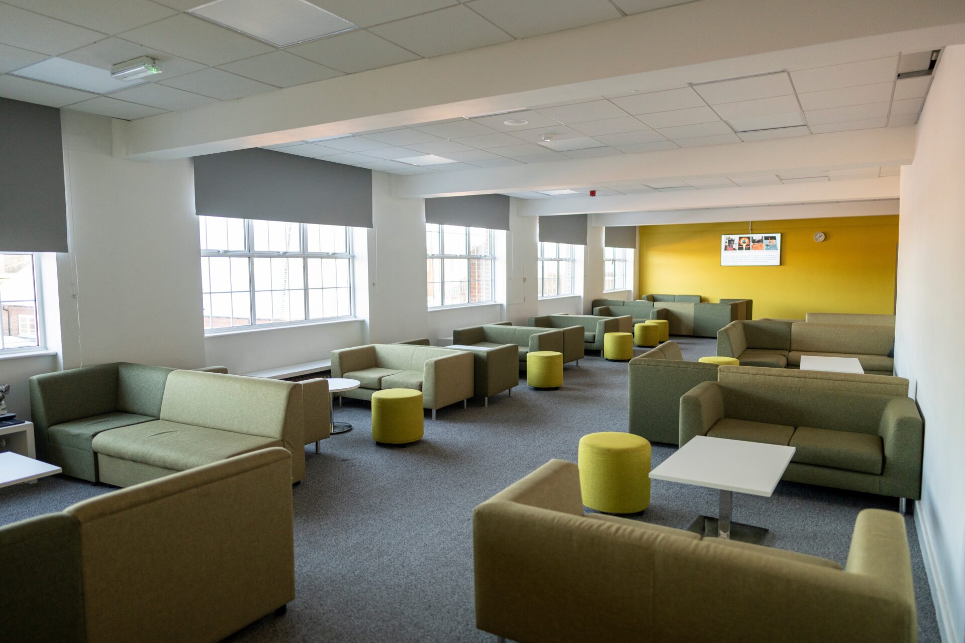 A spacious common room area with multiple sofas and tables.
